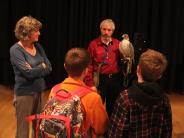 people gathered around a falconer holding a falcon