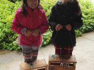 two children holding birdfeeders